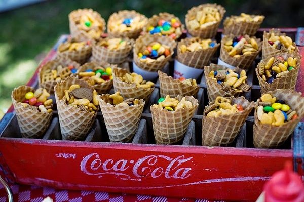 an old coca - cola cooler filled with lots of candy and candies in cones