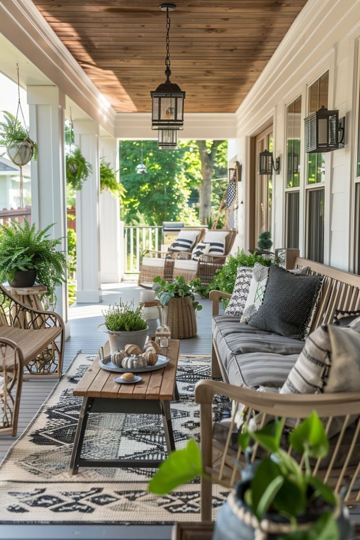 the porch is decorated with wicker furniture and potted plants