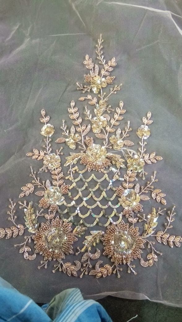 a piece of cloth that has been sewed with gold thread and beads on it