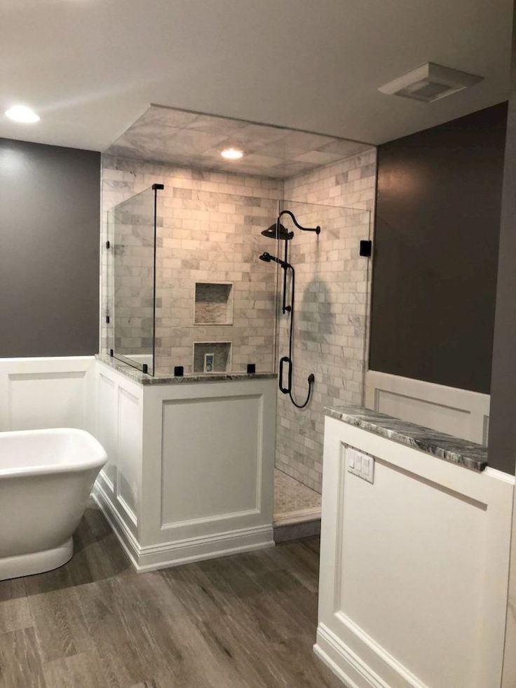 a white bath tub sitting next to a walk in shower