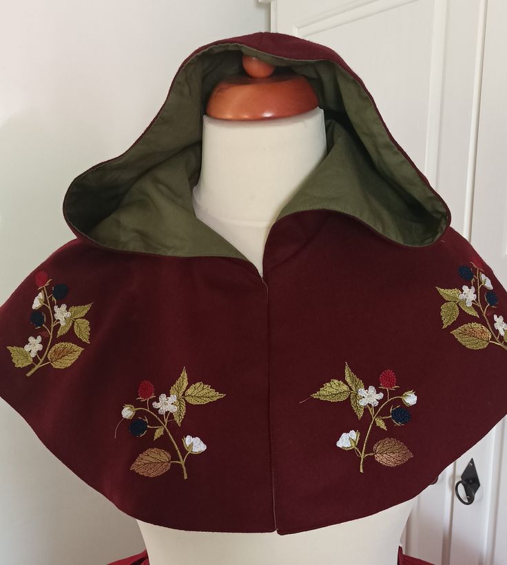 The cape is sewn from wool Fabric, lined with cotton canvas. Decorated with machine embroidery. The front part closes with hooks and eyelets Fits perfectly with a fantasy costume. The color is dark burgundy with a green lining Cape Aesthetic, Fantasy Shoulder Cape, Medieval Cape, Elf Clothing, Leaf Cape, Green Cape, Medieval Style Fall Cape, Elvish Cape For Larp In Fall, Fantasy Embroidery