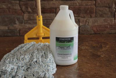 a bottle of cleaner next to a mop on a table