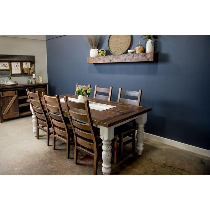 a dining room table and chairs with blue walls