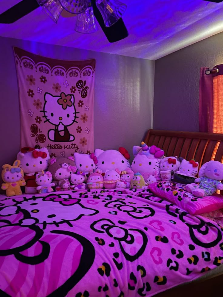 a bed with hello kitty comforters and stuffed animals on it in a purple room