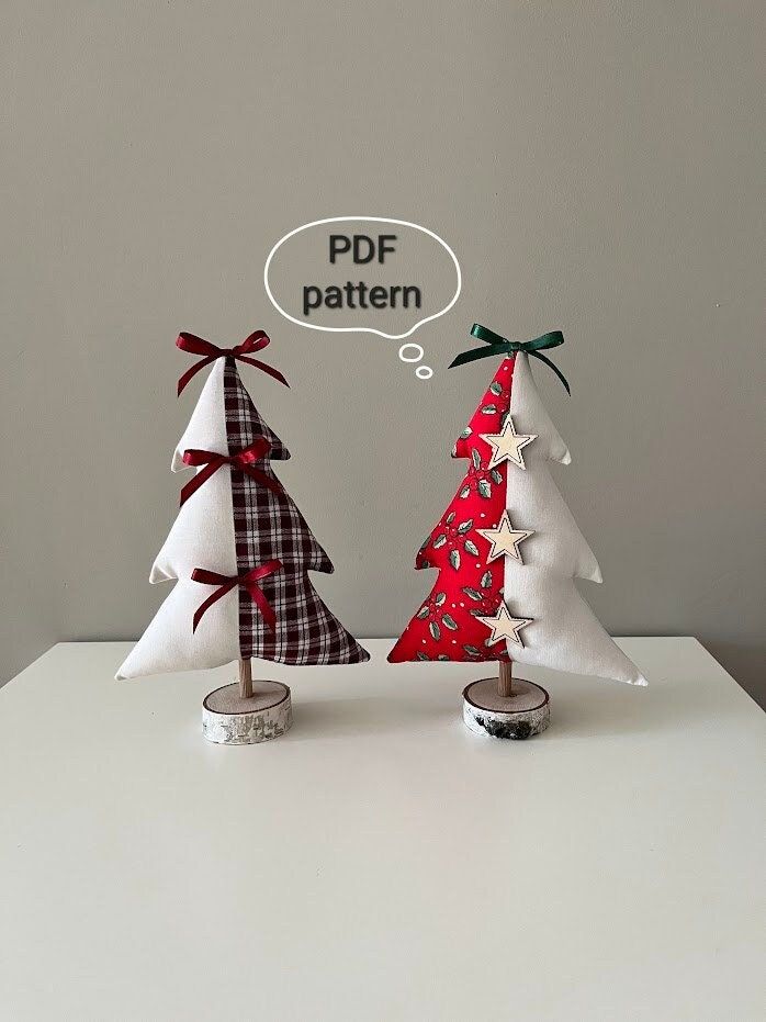 two small christmas trees sitting next to each other on a white table with a speech bubble above them