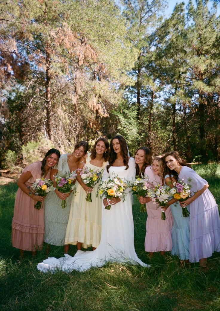 a group of women standing next to each other on top of a lush green field