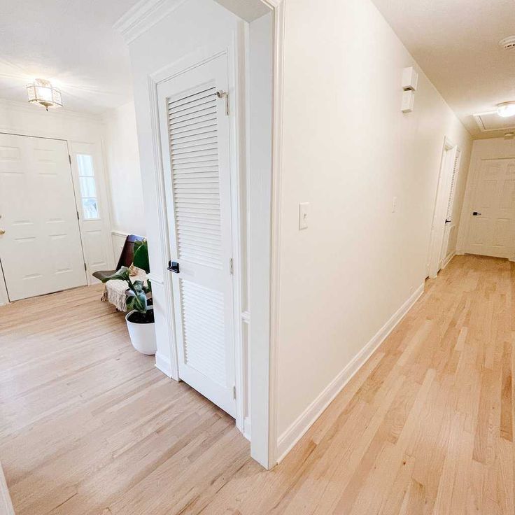 an empty room with white walls and wooden floors