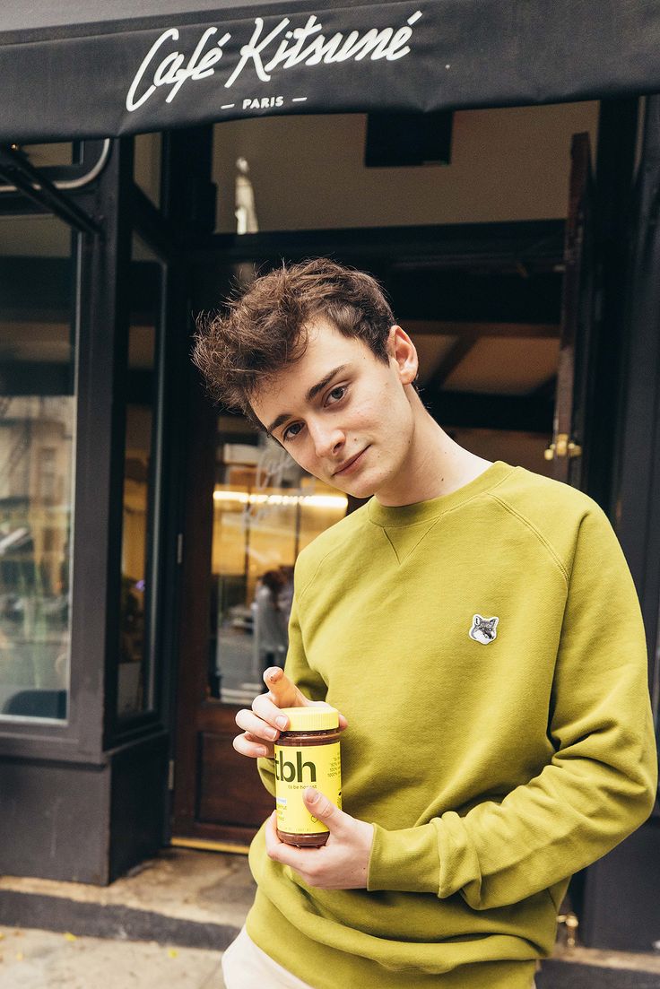 a young man is holding a can of coffee