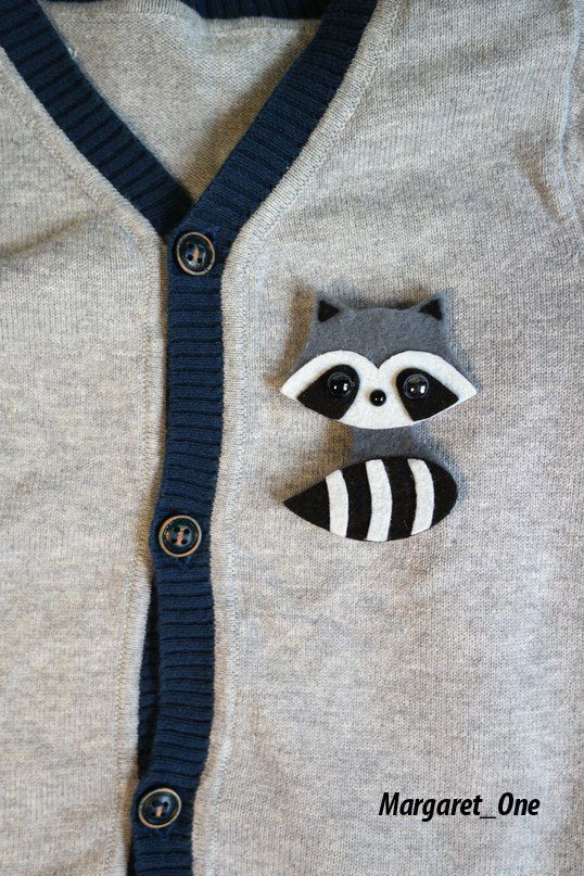 a sweater with a raccoon in the pocket