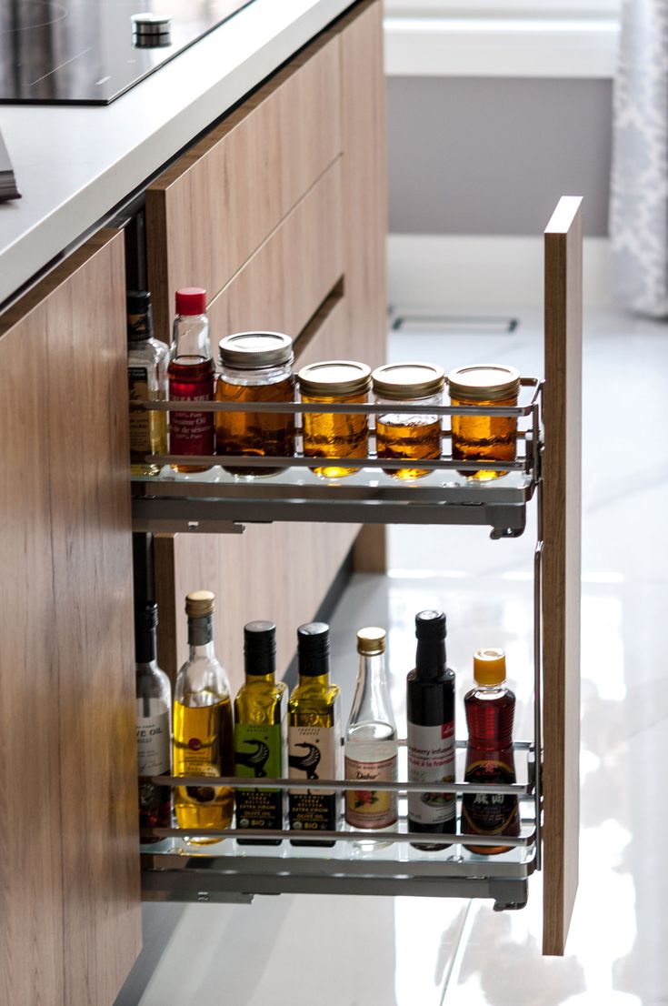 an organized spice rack in a kitchen with spices and condiments on the shelves