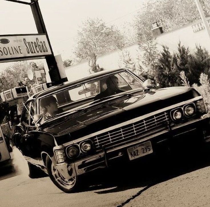 an old car is parked on the side of the road