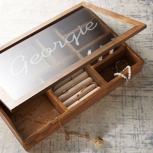 an open wooden box with writing on the glass door and jewelry in it that says george