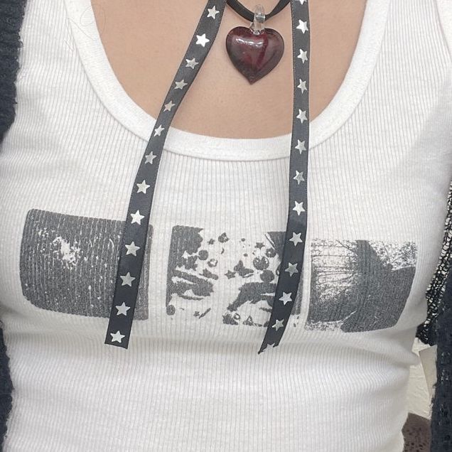 a woman wearing a heart shaped necklace with stars on it