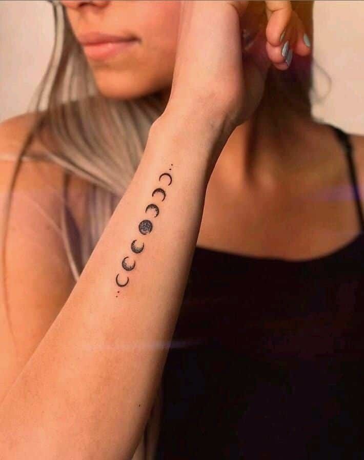 a woman with a tattoo on her arm that says, i love you to the moon and back