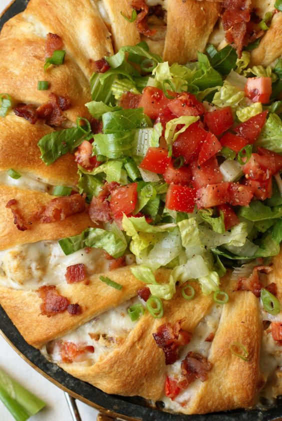 a pizza topped with lettuce, tomatoes and other toppings on a pan