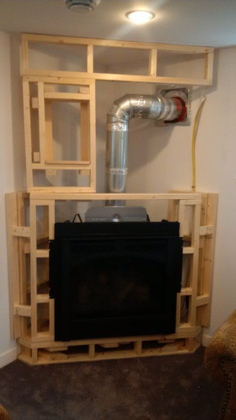 a living room with a fire place in the corner and pipes coming out from it