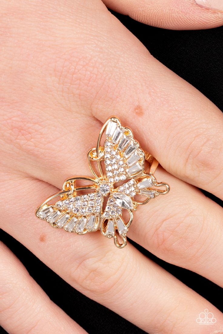 Sparkling with round, teardrop, and emerald cut white rhinestones, a gold butterfly fearlessly flutters atop the finger for a statement-making finish. Features a stretchy band for a flexible fit.

 Sold as one individual ring. Butterfly Rings, Gold Butterfly Ring, Sparkling Rings, Butterfly Ring, June 2022, Paparazzi Accessories, Silver Butterfly, White Rhinestone, Gold Butterfly