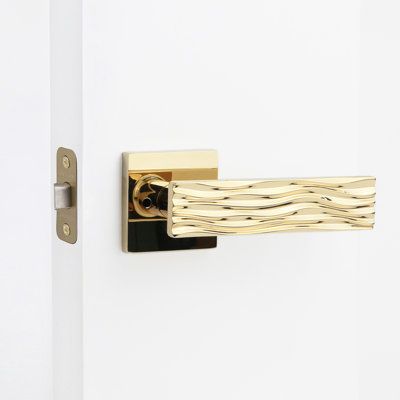 a close up of a door handle on a white door with wood grained design