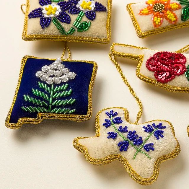 embroidered ornaments are displayed on a white surface