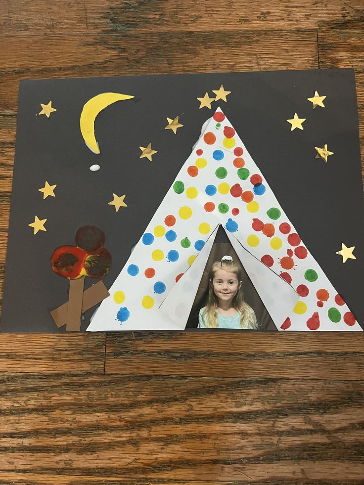 a child's photo in a paper tent with stars and moon on the side