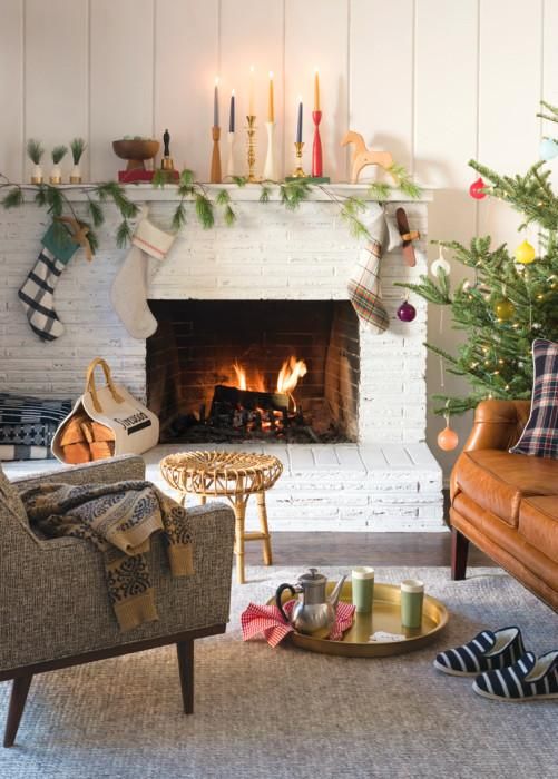 a living room filled with furniture and a fire place next to a christmas decorated fireplace