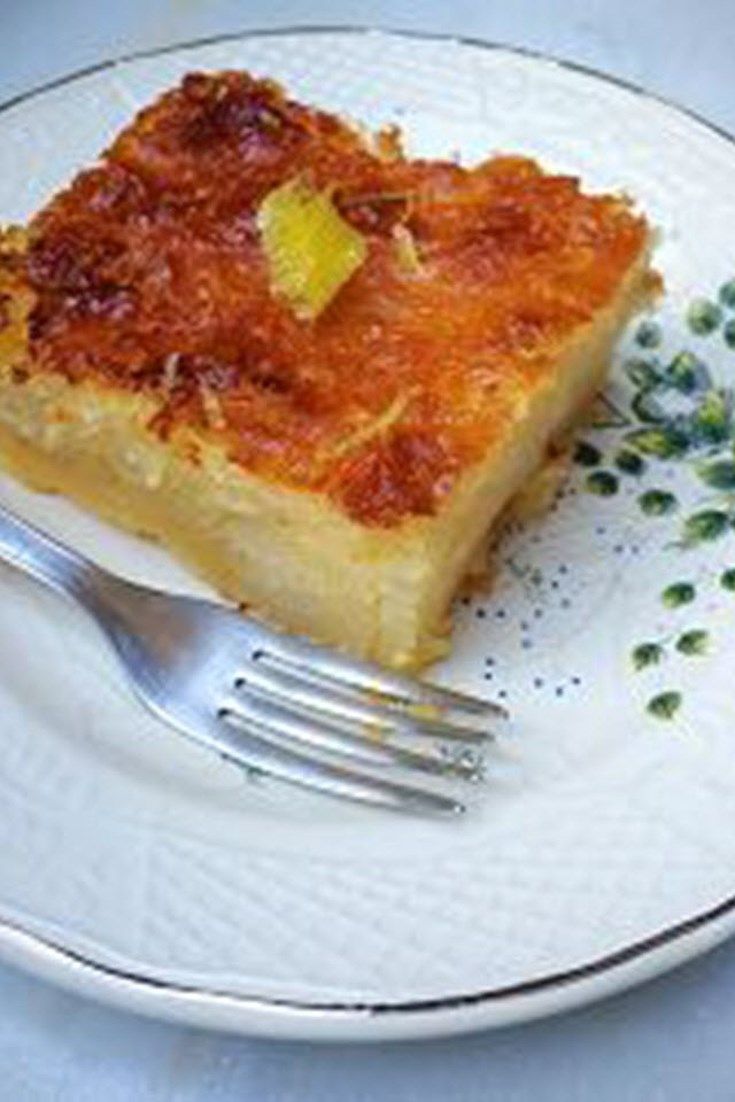 a piece of quiche on a plate with a fork and garnishes