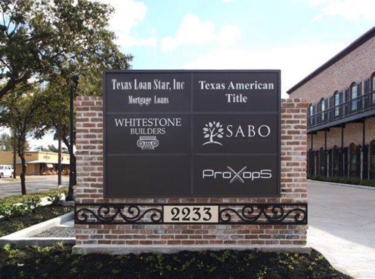 a sign for the texas land and air texas title in front of a brick building