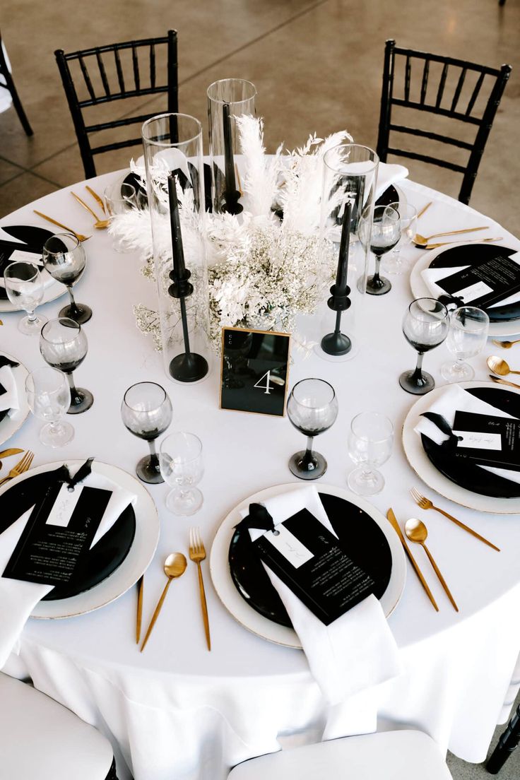 the table is set with black and white place settings