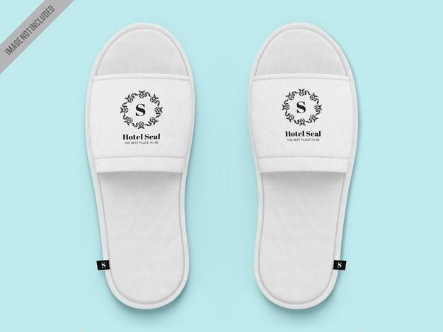 a pair of white slippers on top of a blue background with the letter s