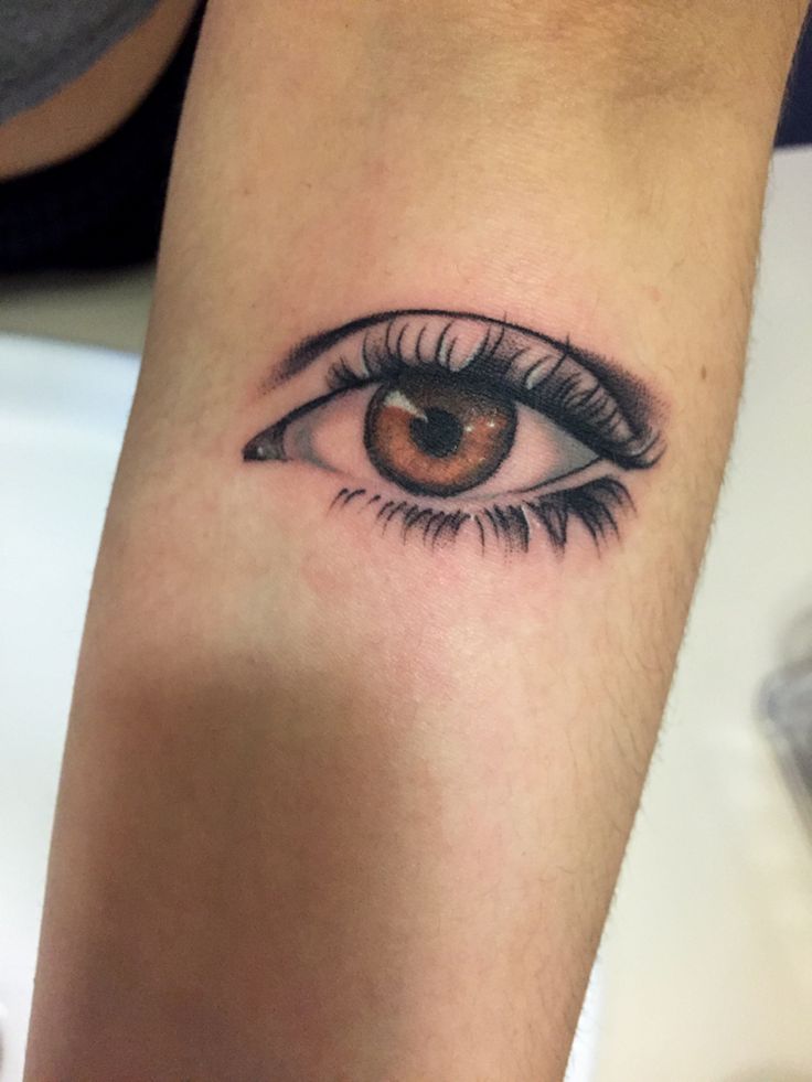 a woman's arm with an eye tattoo on it