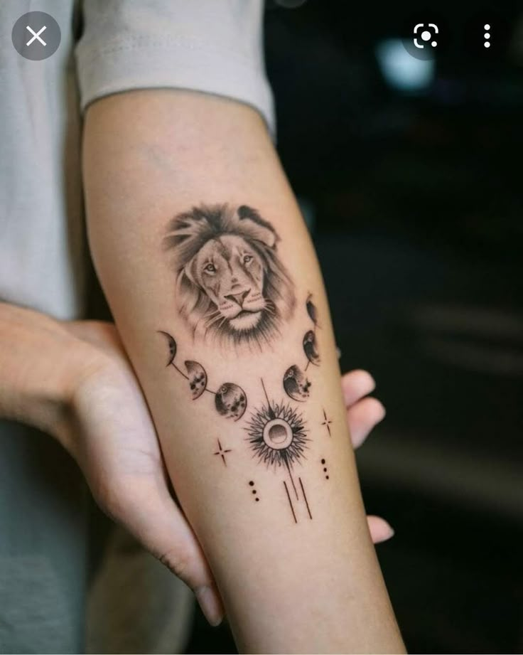 a woman's arm with a lion and sunflower tattoo on the left forearm