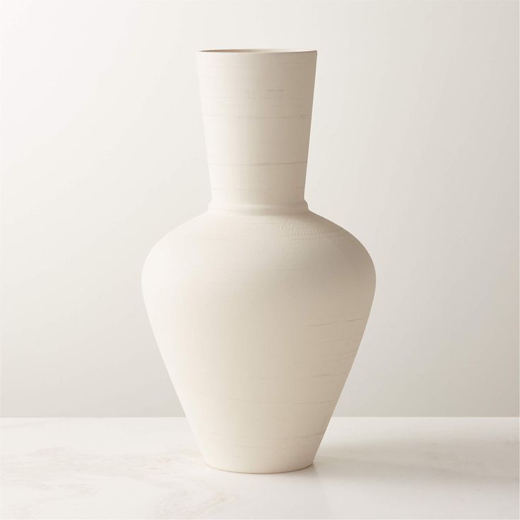 a white vase sitting on top of a table