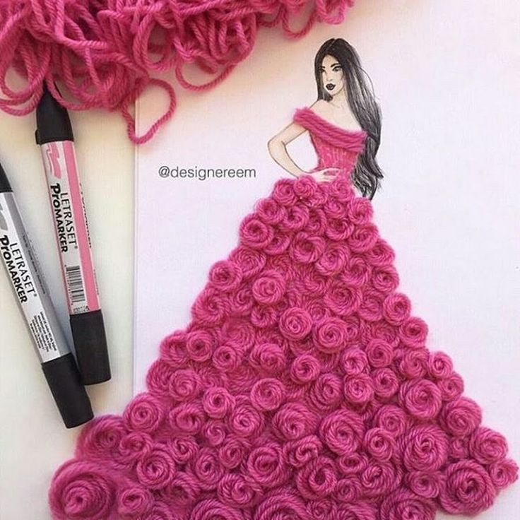 a crochet dress made out of pink yarn and rolled roses next to markers