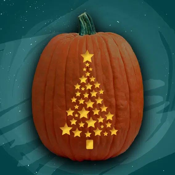 a pumpkin decorated with gold stars and a christmas tree cut out of it's side