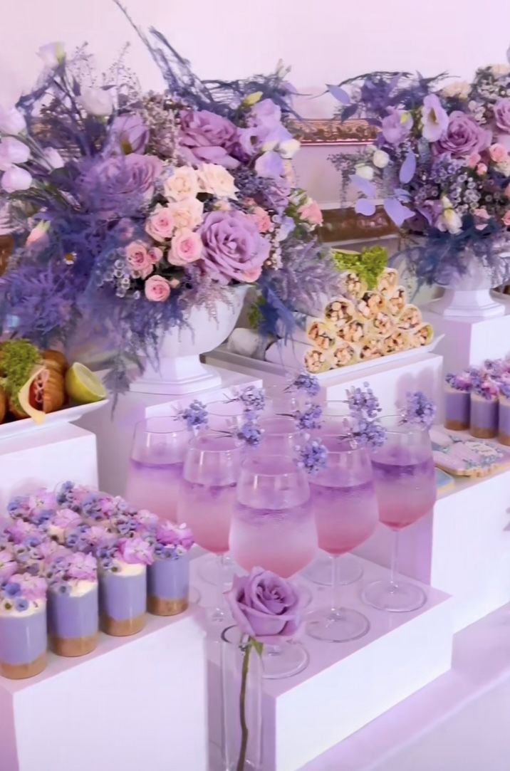 a table filled with lots of different types of desserts and flowers in vases