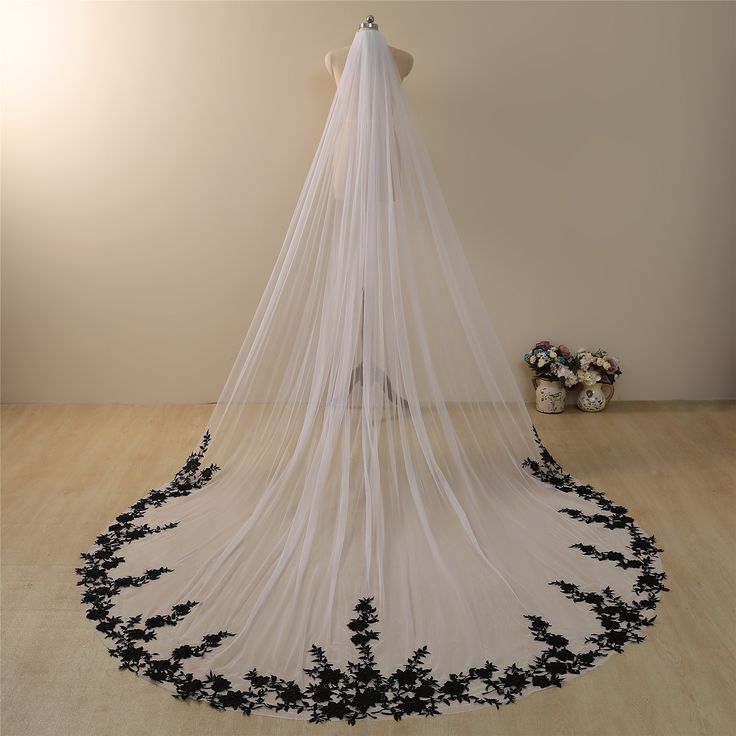 a white wedding veil with black flowers on it