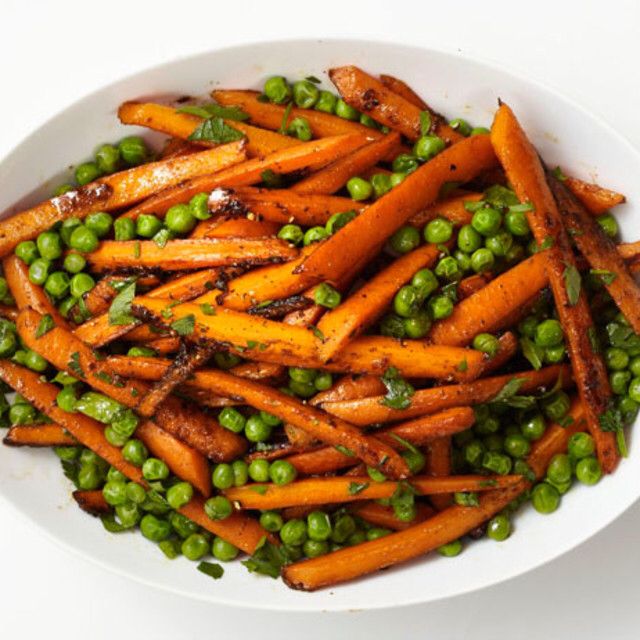 a white bowl filled with peas and carrots