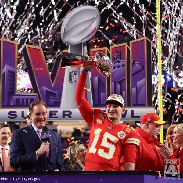 a football player holding up a trophy in front of confetti