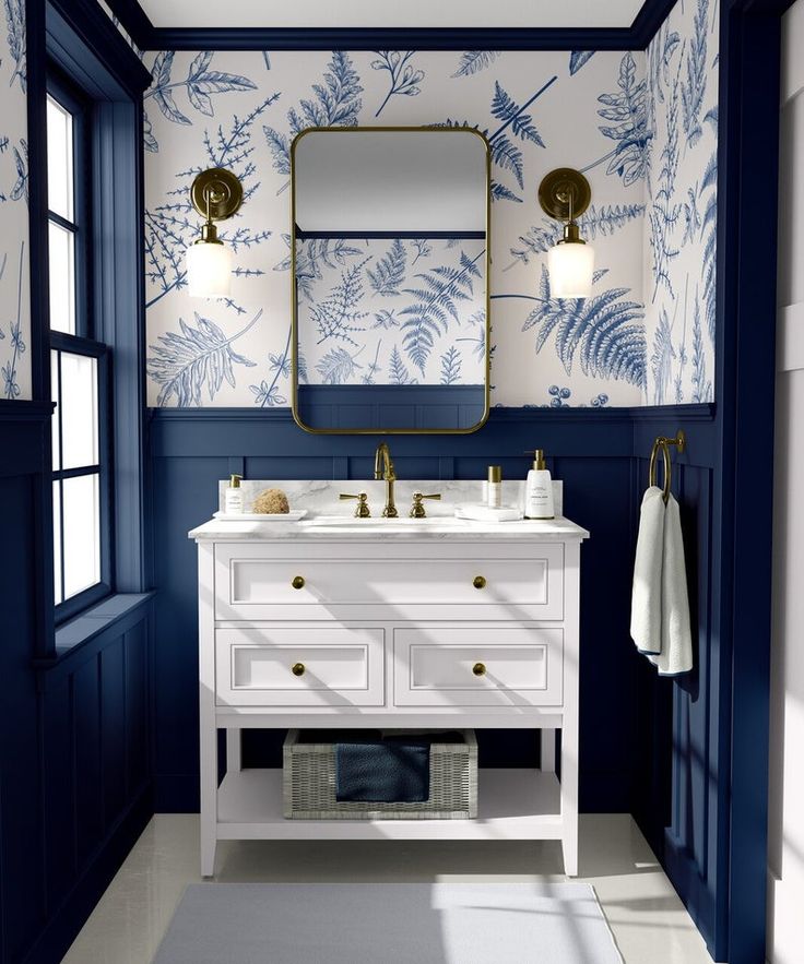 a bathroom with blue and white wallpaper, two sinks and a mirror on the wall