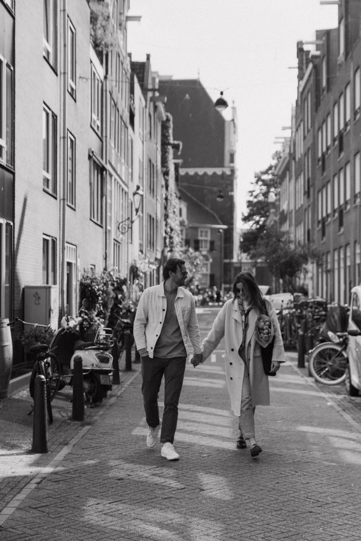 two people walking down the street holding hands