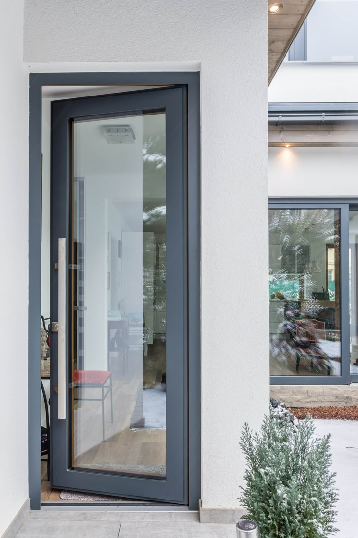 an open door on the side of a building with a potted plant next to it