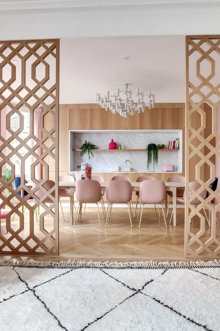 a dining room with pink chairs and a chandelier