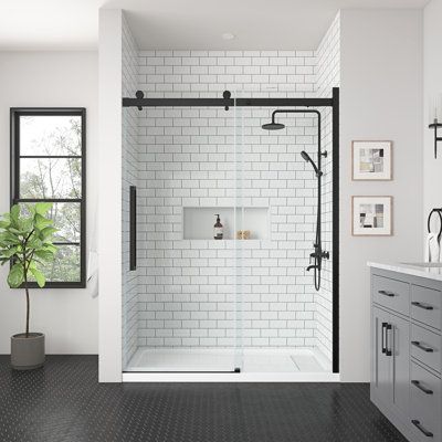 a bathroom with black and white tile flooring, a walk - in shower and sink