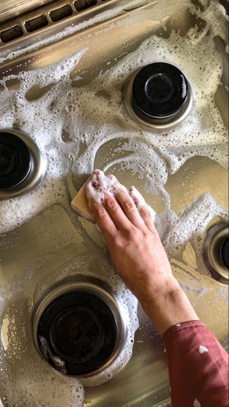 a person washing dishes in a sink with soap on the top and water running down the drain