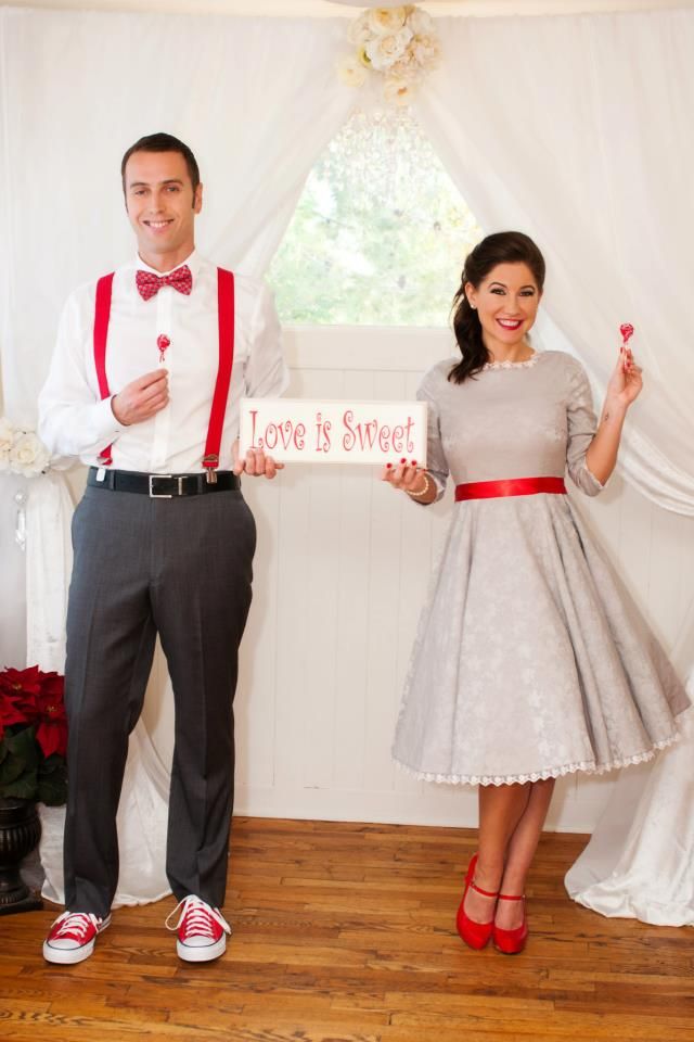 a man and woman standing next to each other in front of a sign that says love is street