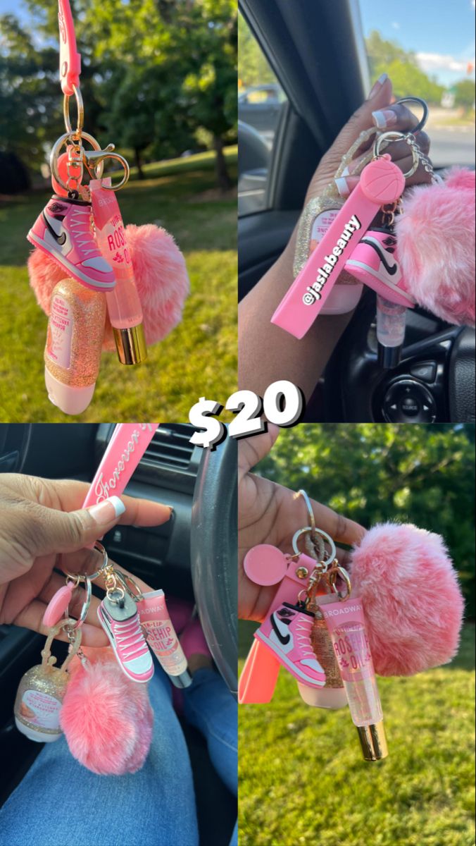 the keychain is hanging from the car's steering wheel, and it has pink pom - poms