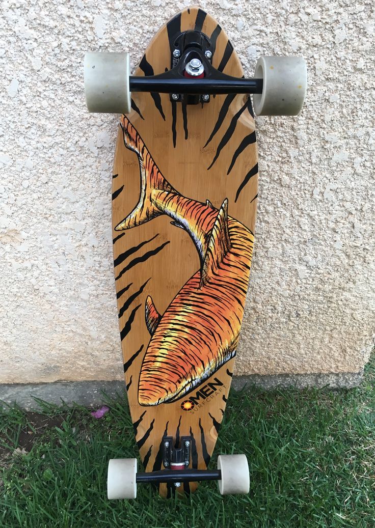 a skateboard with an image of a tiger on it's front end is leaning against a wall