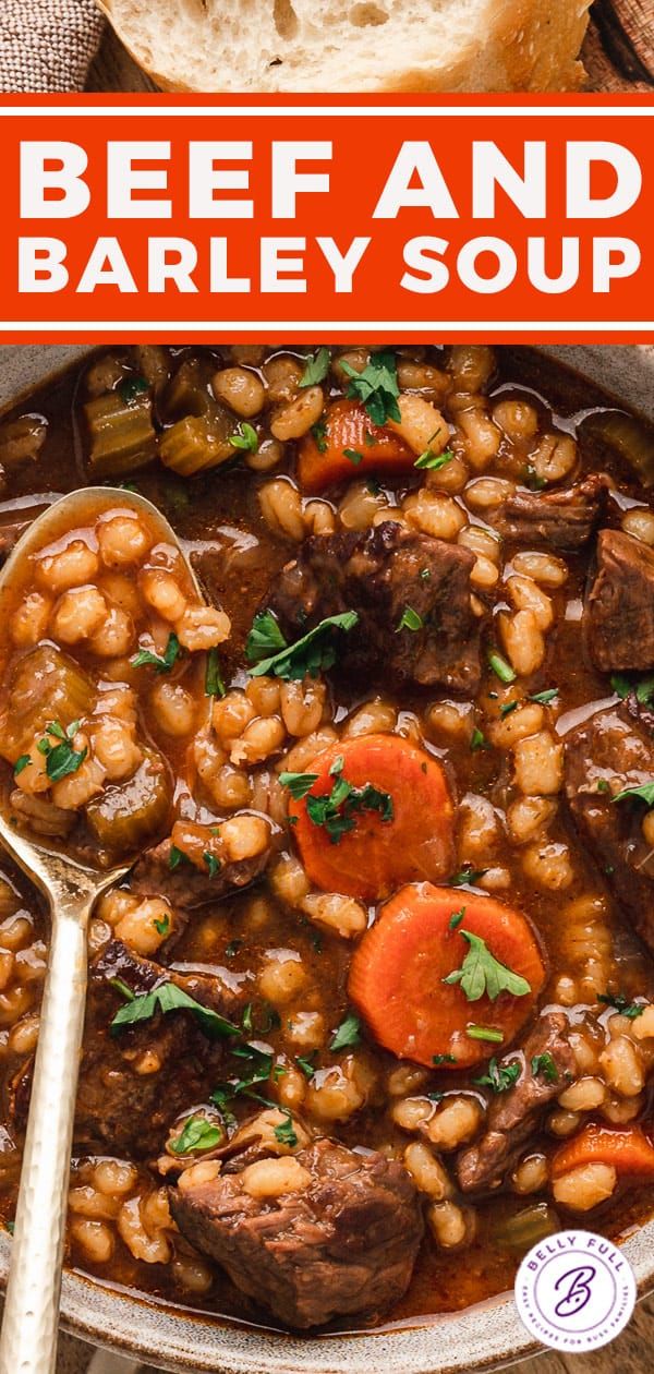 beef and barley soup in a bowl with bread on the side