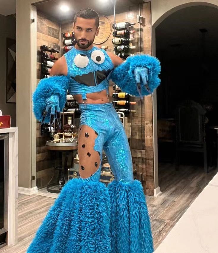 a man in blue costume standing next to a wine rack