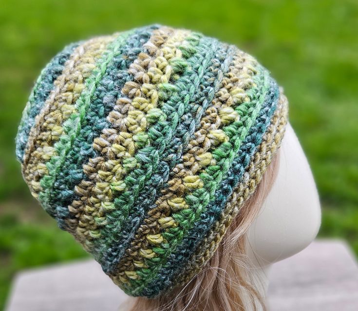 a close up of a woman's head wearing a knitted beanie hat